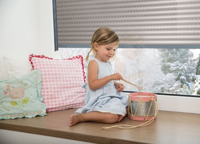 MaiFen GmbH - Fenster- u. Sonnenschutztechnik 1 spielendes Mädchen mit einer Trommel sitzt vor einem Rollladen