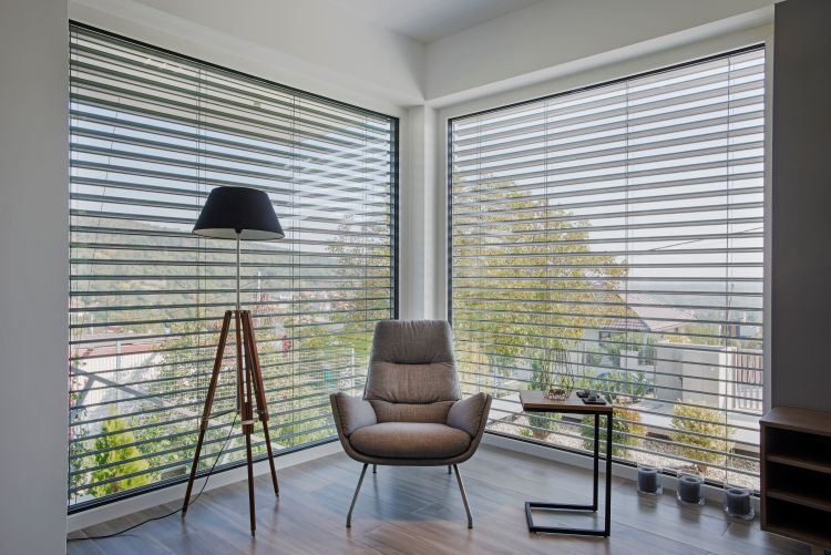 Zwei große Fenster zeigen Raffstores von innen