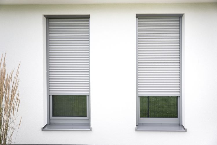 Zwei Fenster, die mit Rollläden ausgestattet sind